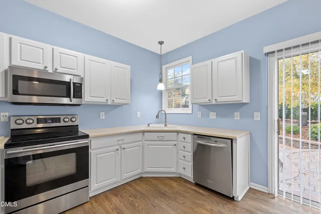 a kitchen with a refrigerator a stove top oven a sink and dishwasher