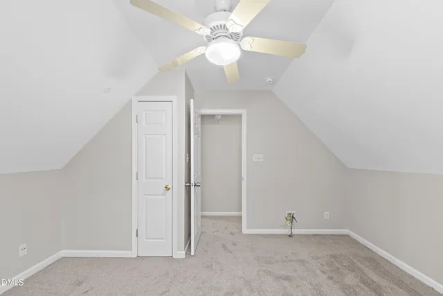 an empty room with a chandelier fan