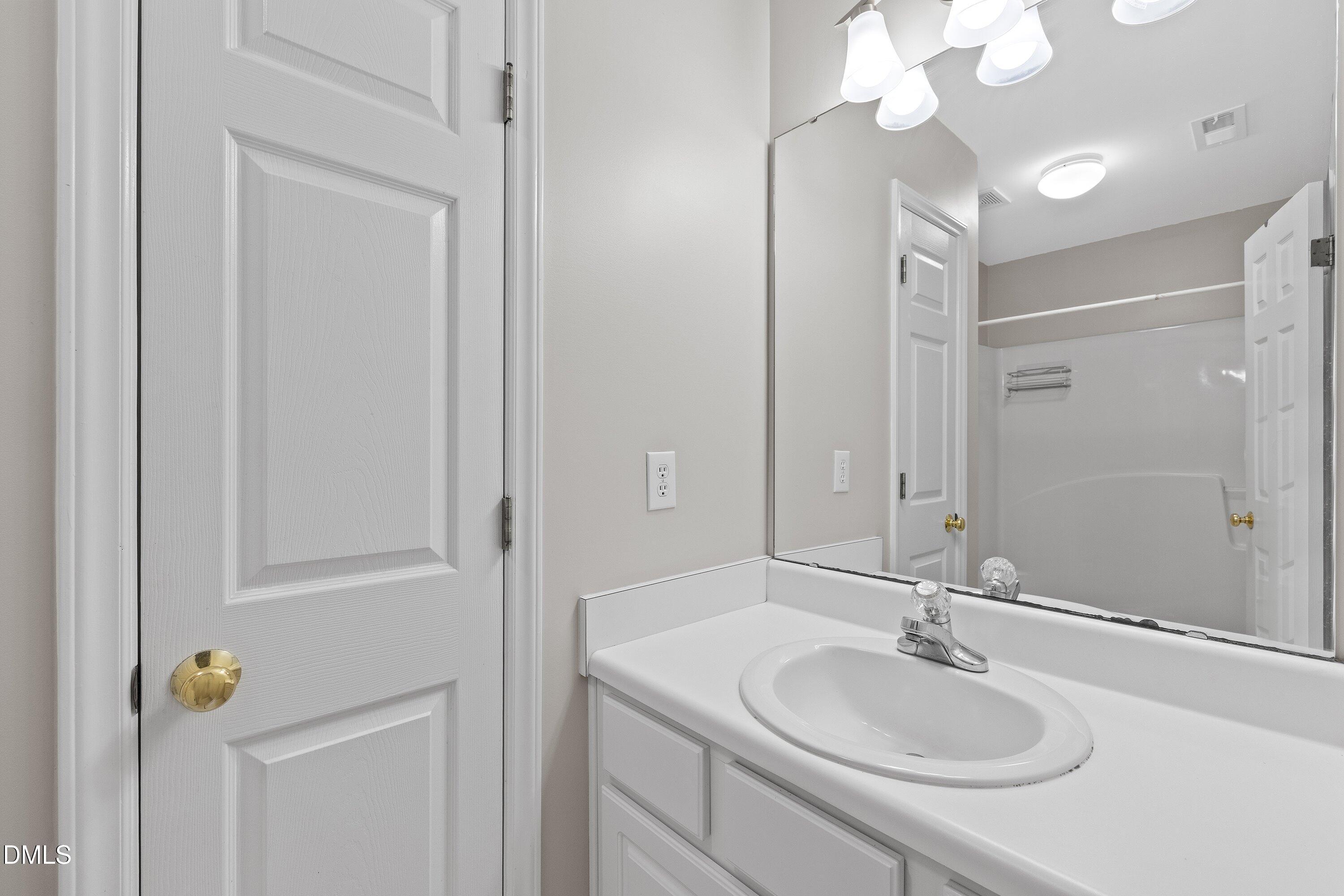 102 College Avenue Durham, NC 27713 - Photo 25 of 39 a bathroom with a granite countertop sink a light fixture and a mirror