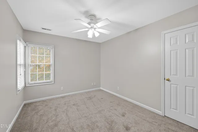 an empty room with a ceiling fan and a fan