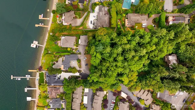 an aerial view of residential house with outdoor space and trees all around