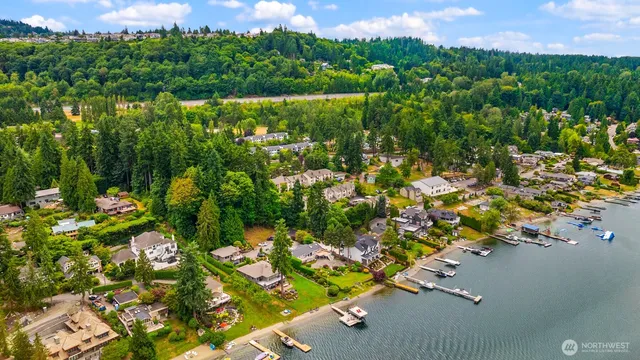 an aerial view of a houses with a yard and lake view