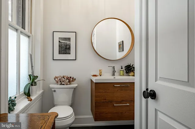 a bathroom with a toilet a sink and mirror