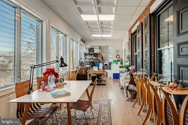 a view of a dining room with furniture one side kitchen view and a large window