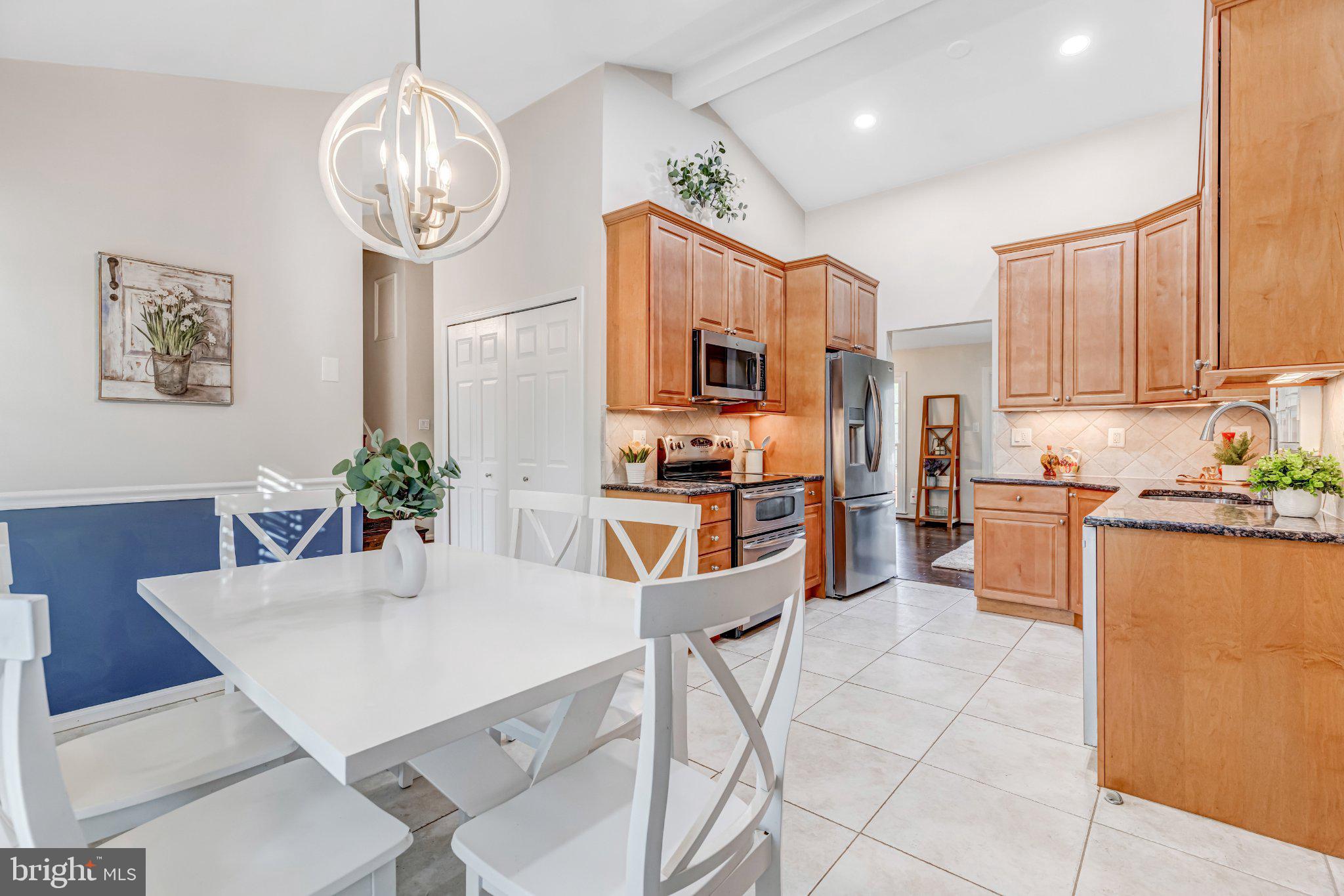 8619 Nanlee Drive Springfield, VA 22152 - Photo 11 of 73 a kitchen with stainless steel appliances kitchen island granite countertop a refrigerator a stove a sink dishwasher and white cabinets with wooden floor