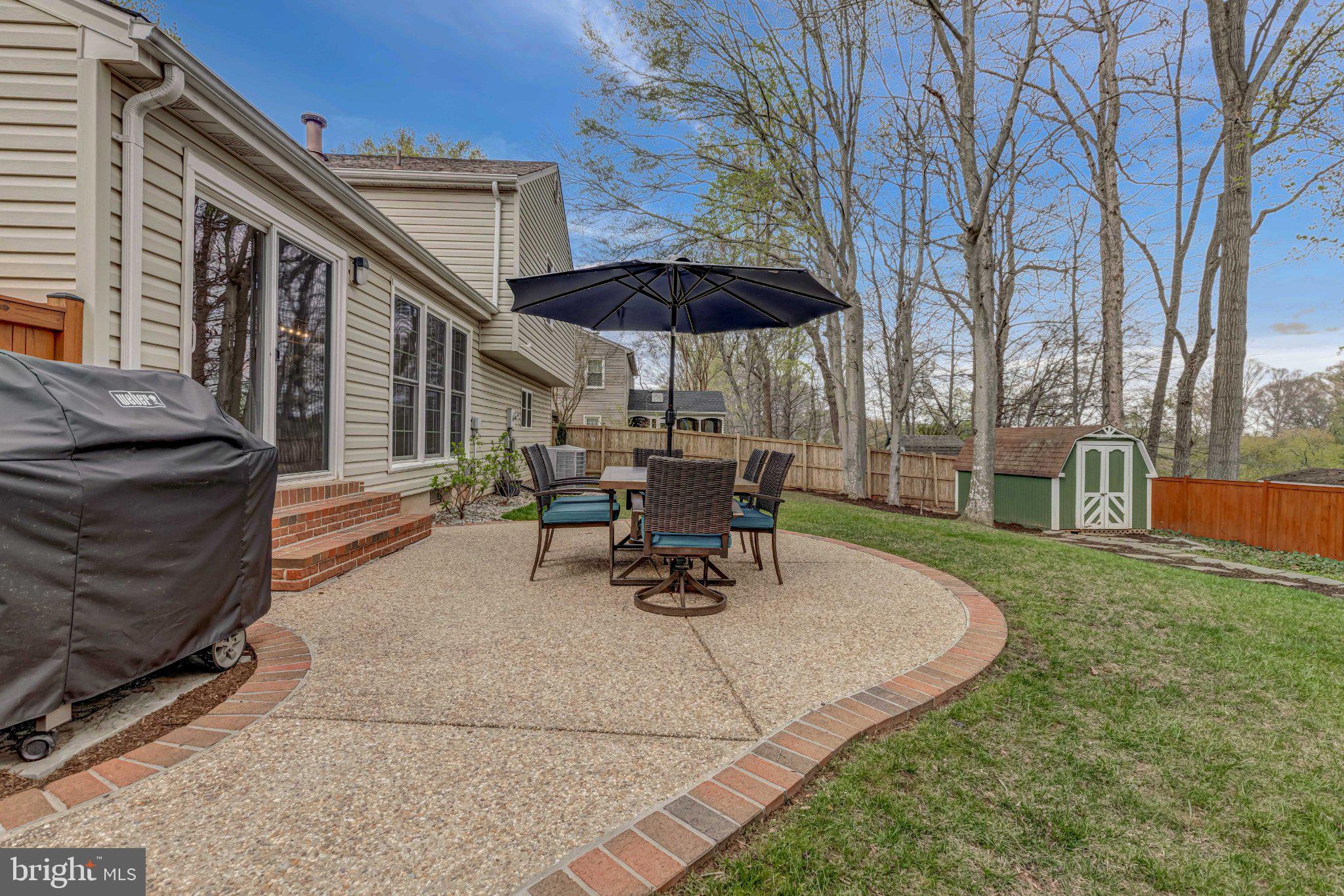 8619 Nanlee Drive Springfield, VA 22152 - Photo 66 of 73 a view of a patio with a table and chairs under an umbrella