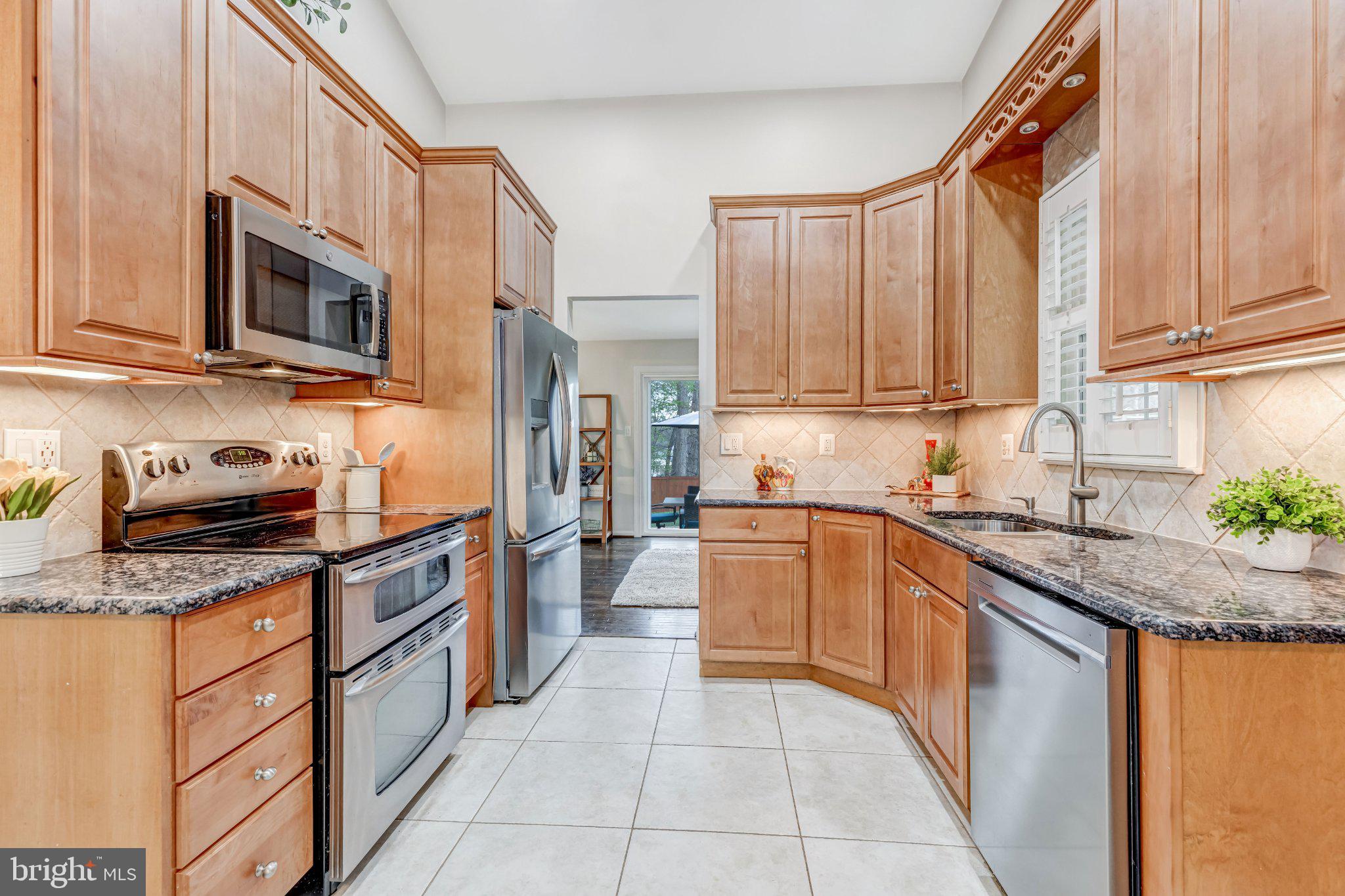 8619 Nanlee Drive Springfield, VA 22152 - Photo 9 of 73 a kitchen with stainless steel appliances granite countertop a stove top oven a sink dishwasher and a microwave oven on the granite countertops