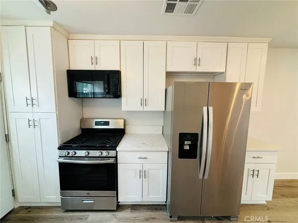 a kitchen with stainless steel appliances a refrigerator a stove and a microwave