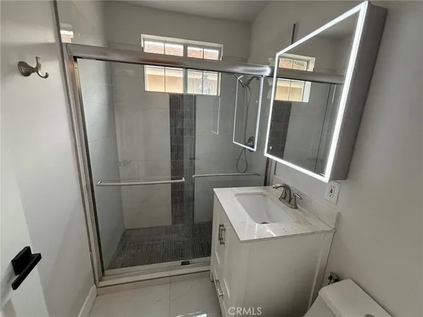 a bathroom with a sink and mirror with toilet