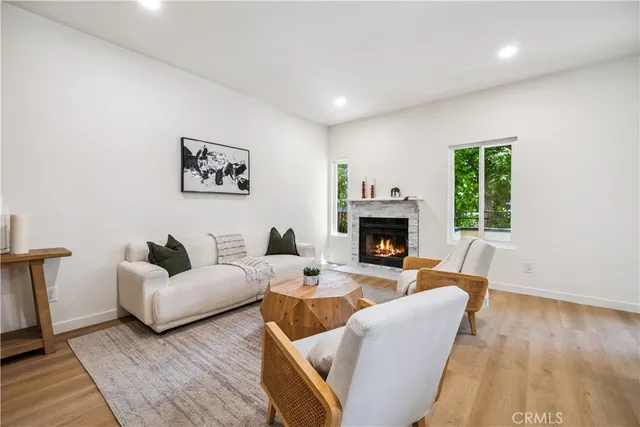 a living room with furniture two window and a fireplace