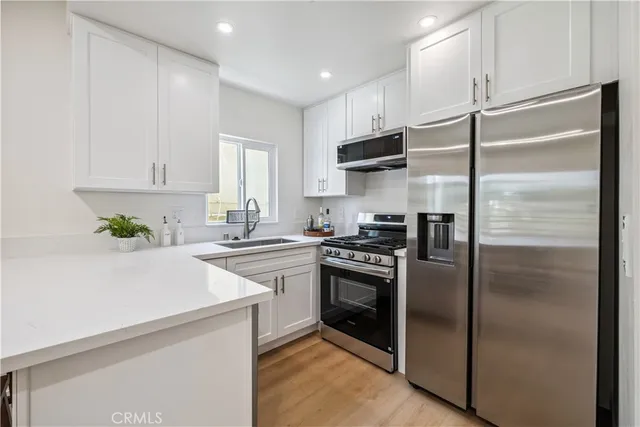 a kitchen with a refrigerator sink and cabinets