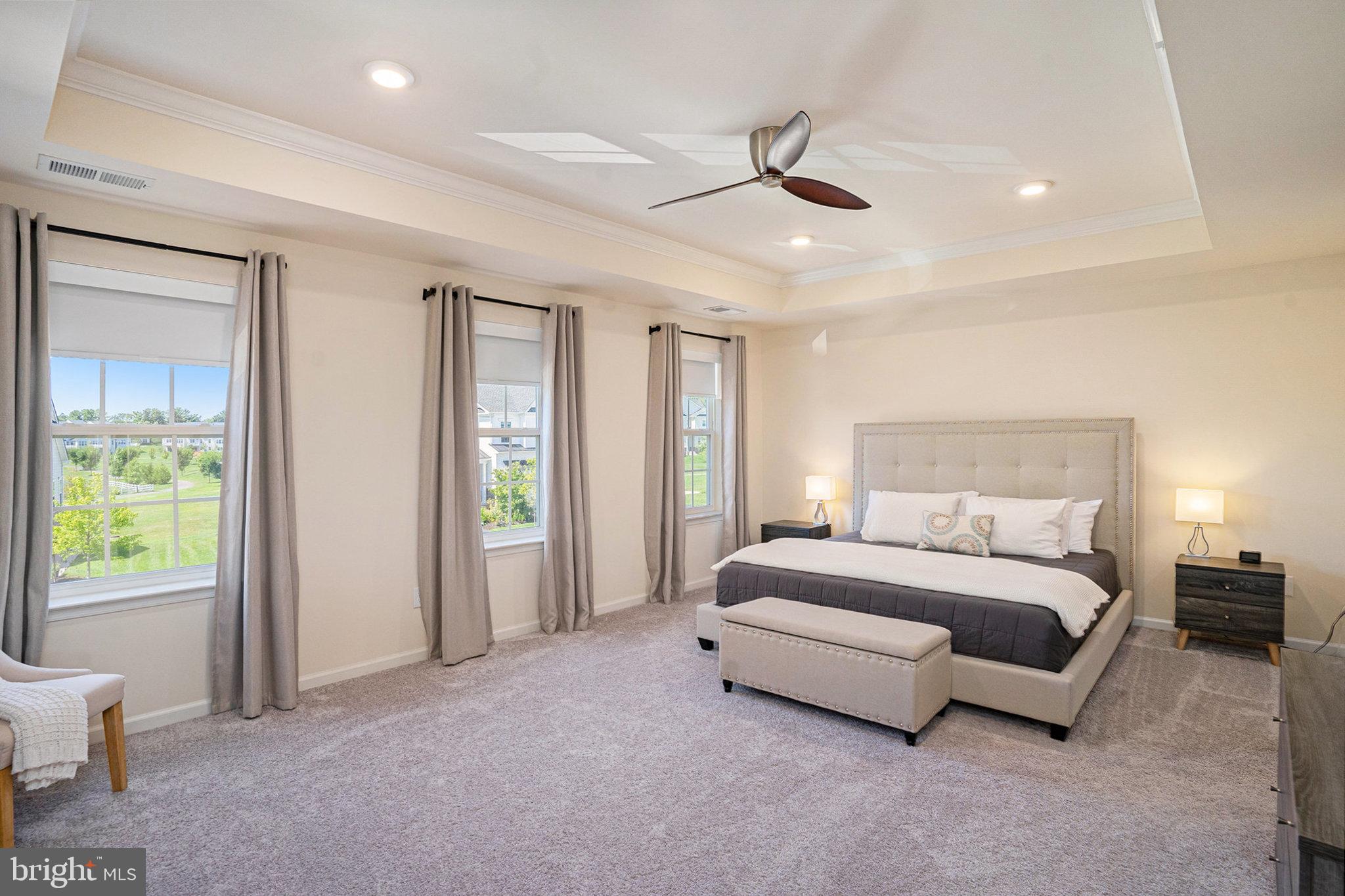 421 Lee Place Exton, PA 19341 - Photo 10 of 58 a spacious bedroom with a bed a chandelier and a window