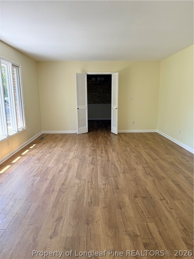 425 Dunmore Road Fayetteville, NC 28303 - Photo 5 of 21 an empty room with wooden floor closet and windows