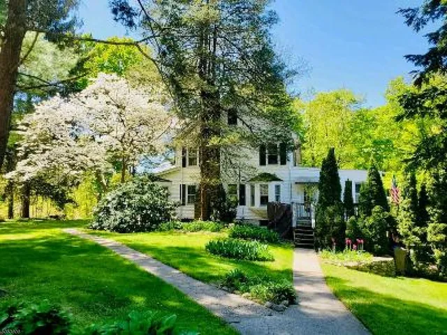 a front view of a house with plants and garden