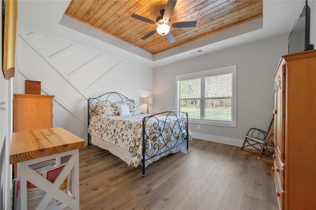 11700 Wildcat Bridge Road Danielsville, GA 30633 - Photo 21 of 49 a bedroom with a bed next to a window with wooden floor