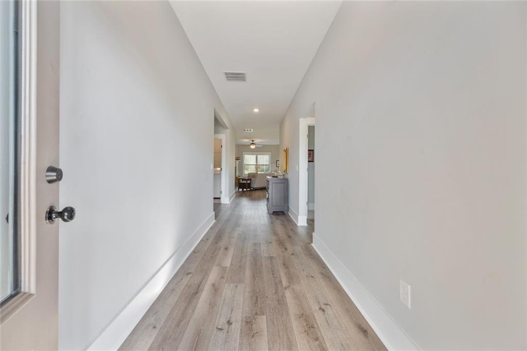 11700 Wildcat Bridge Road Danielsville, GA 30633 - Photo 6 of 49 a view of a hallway with wooden floor and a bathroom