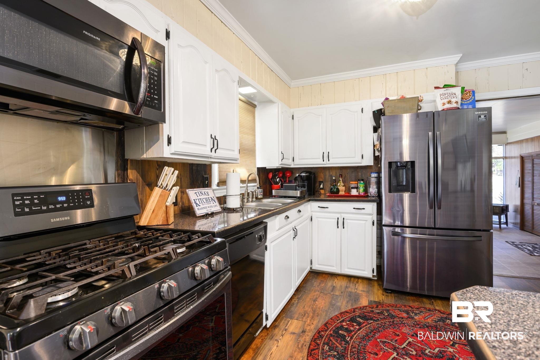 4105 Libby Drive Mobile, AL 36693 - Photo 8 of 26 Kitchen featuring crown molding, appliances with stainless steel finishes, white cabinetry, backsplash, and dark hardwood / wood-style floors