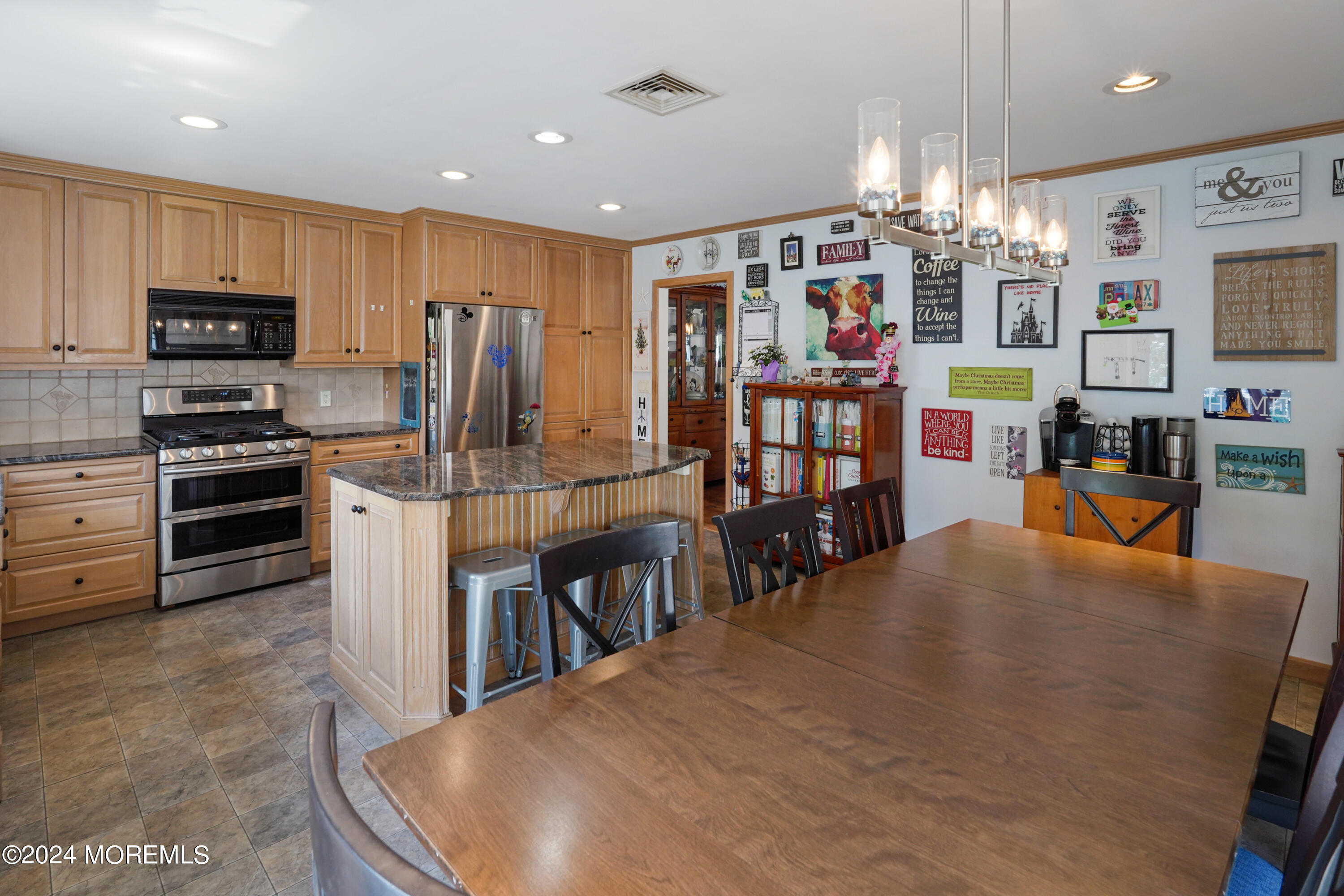 403 Union Lane Brielle, NJ 08730 - Photo 22 of 31 a kitchen with stainless steel appliances kitchen island granite countertop a refrigerator a stove top oven a sink dishwasher and white cabinets with wooden floor