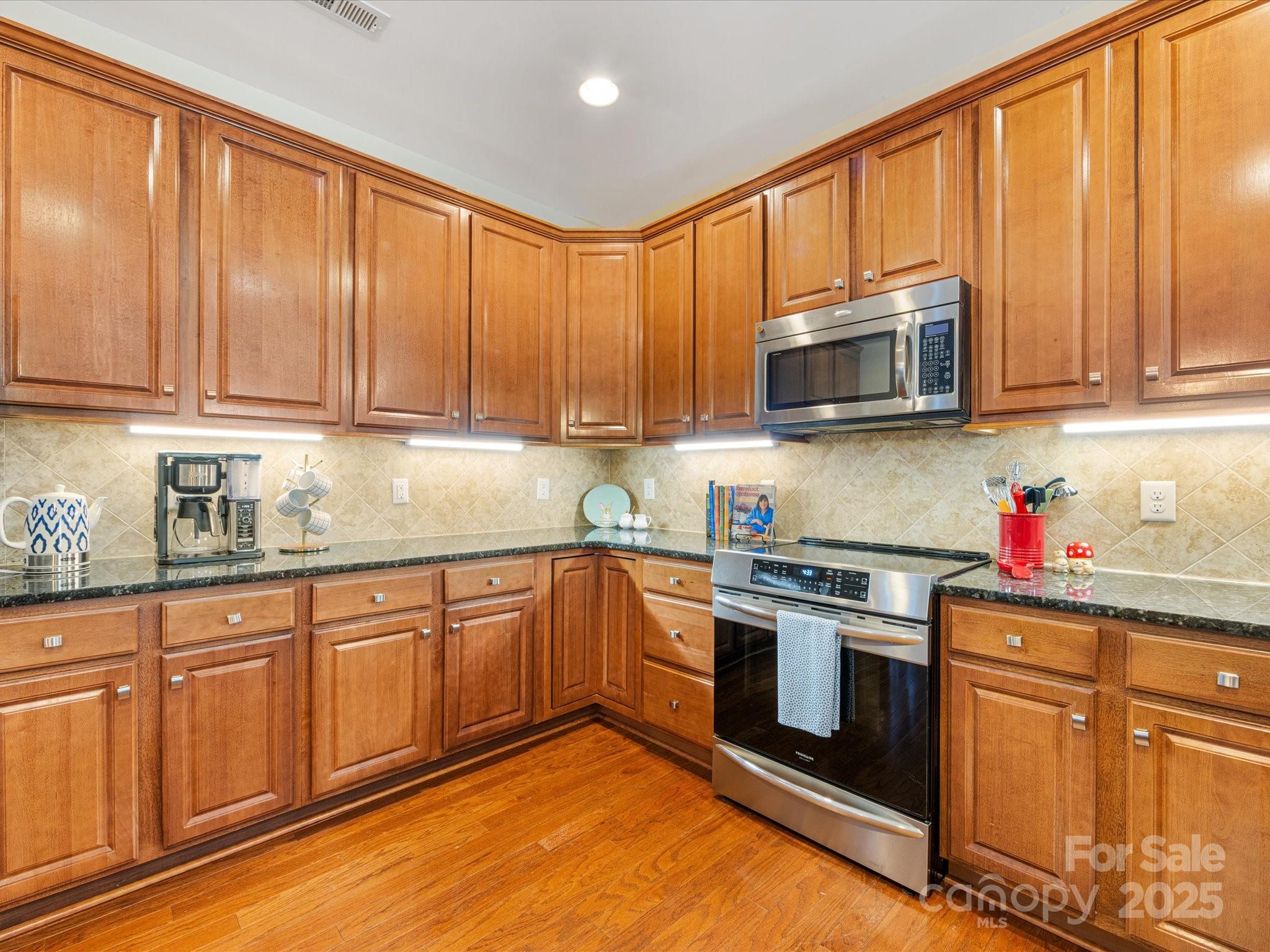 4434 Patriots Hill Road Mint Hill, NC 28227 - Photo 6 of 31 a kitchen with granite countertop wooden cabinets stainless steel appliances and a sink