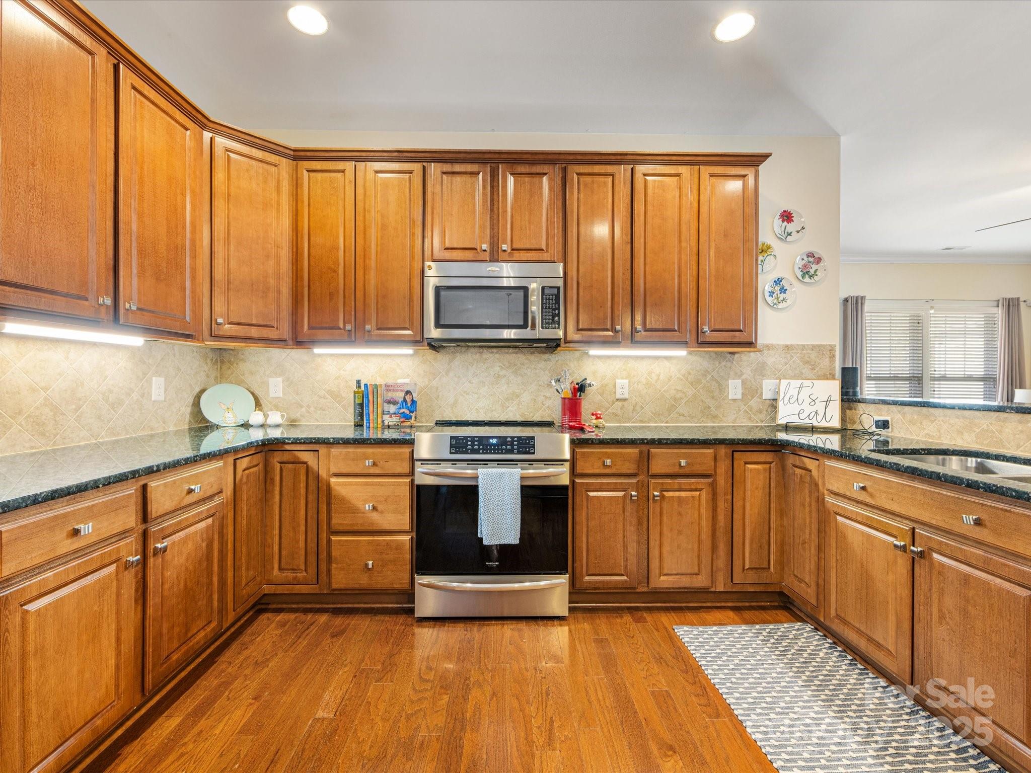 4434 Patriots Hill Road Mint Hill, NC 28227 - Photo 7 of 31 a kitchen with stainless steel appliances granite countertop wooden cabinets a sink and a stove