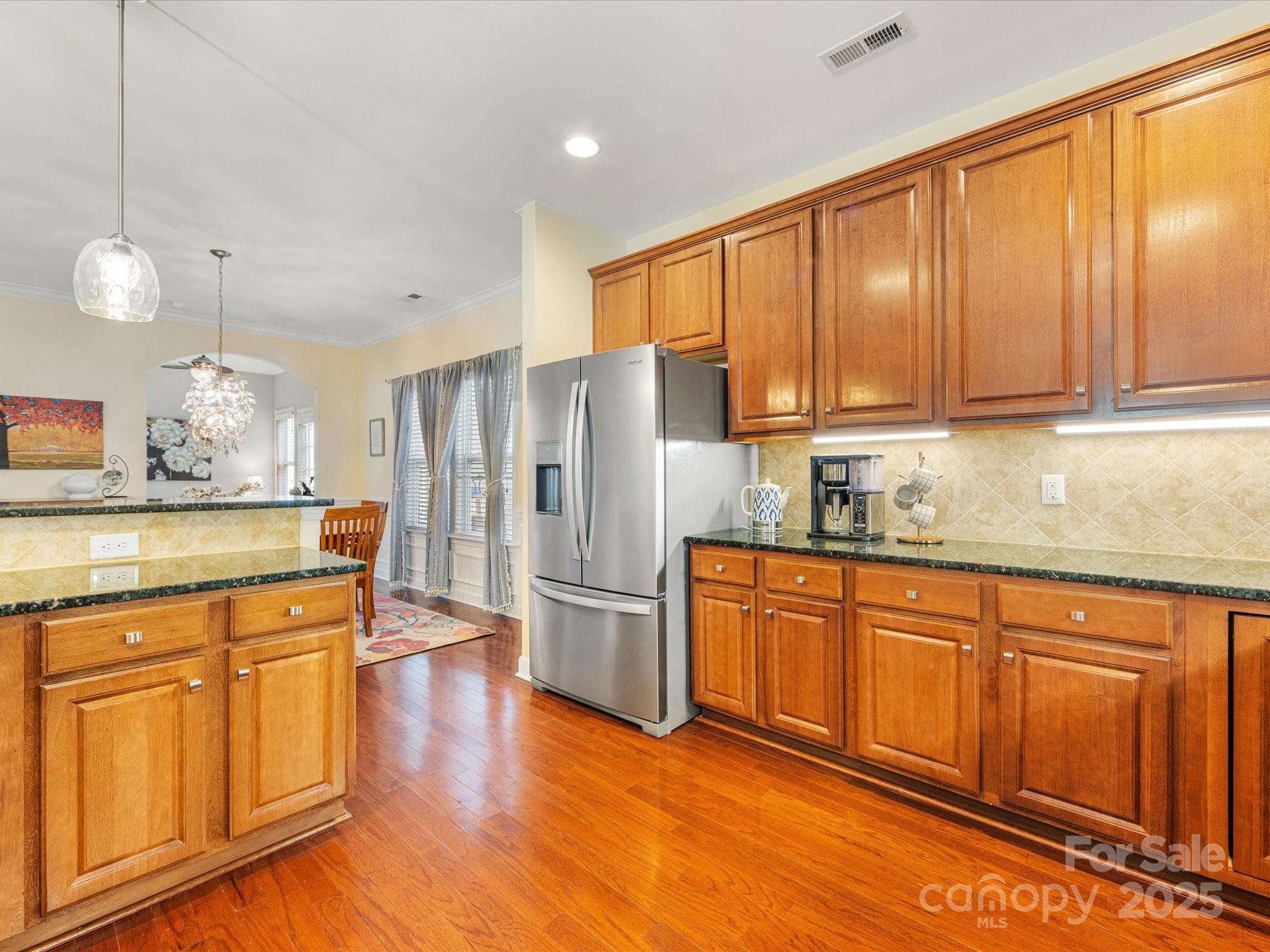 4434 Patriots Hill Road Mint Hill, NC 28227 - Photo 8 of 31 a kitchen with stainless steel appliances granite countertop a refrigerator a sink dishwasher a stove and white cabinets with wooden floor