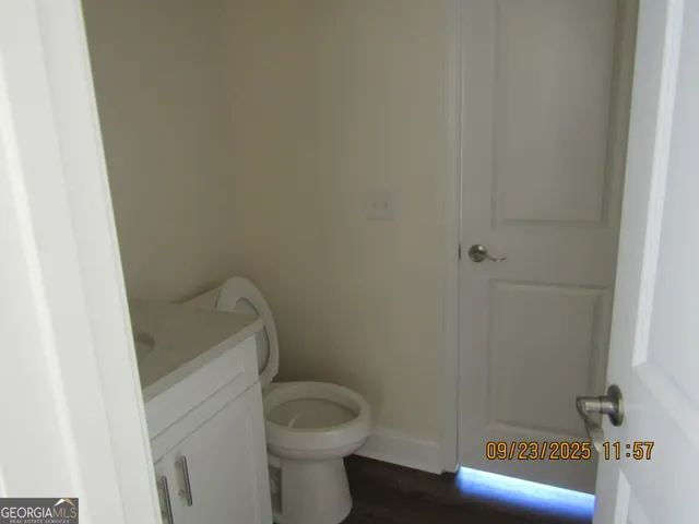 a bathroom with a granite countertop toilet and a sink