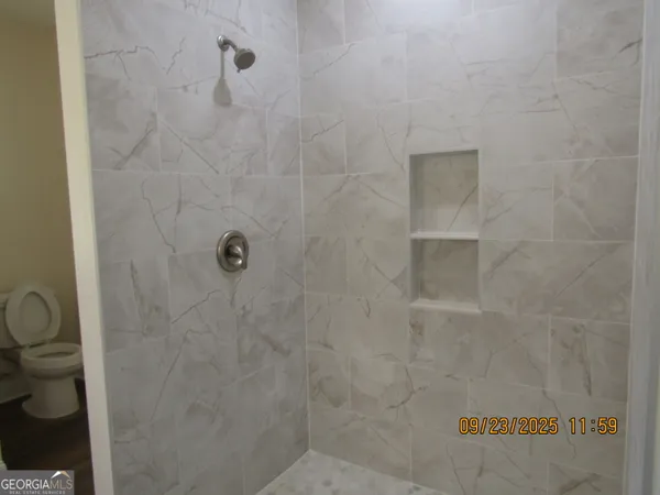 a bathroom with a toilet and a shower