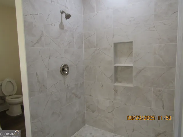 a bathroom with a toilet and a shower