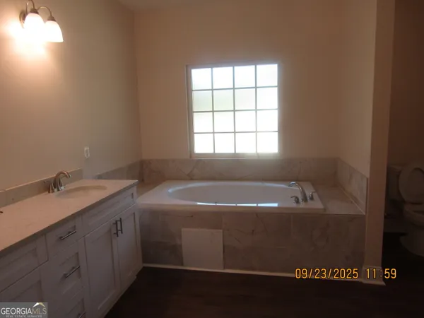 a bathroom with a tub sink and mirror