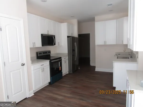 a kitchen with a refrigerator stove and wooden cabinets