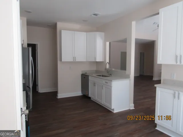 a kitchen with granite countertop a refrigerator and a stove top oven