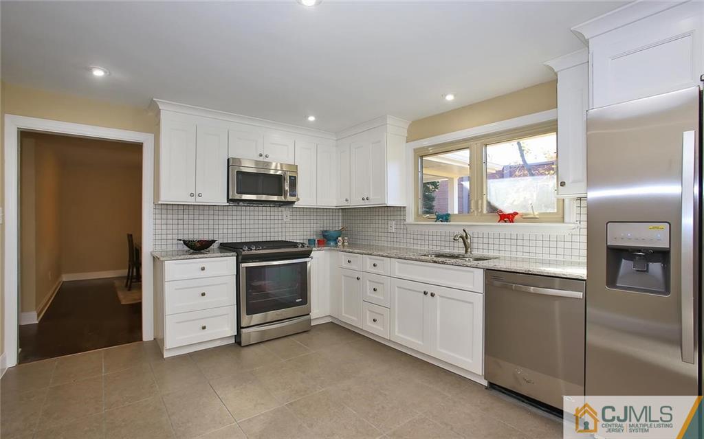 4 Carpender Road New Brunswick, NJ 08901 - Photo 8 of 21 a kitchen with granite countertop white cabinets and stainless steel appliances