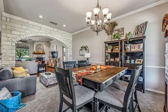 a outdoor dining room with furniture a rug and a chandelier