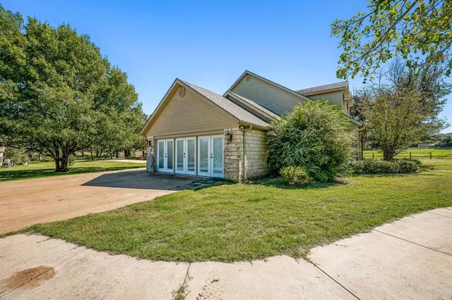 a front view of a house with a yard and trees