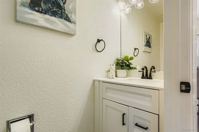 a bathroom with a granite countertop sink a mirror and vanity