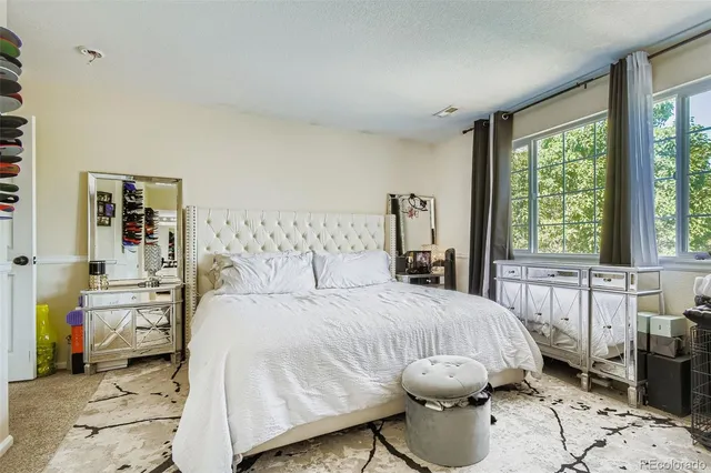 a bedroom with a bed and large windows