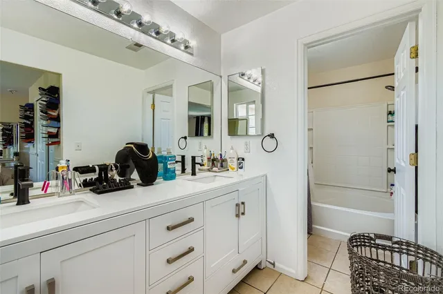 a bathroom with a double vanity sink a mirror a bathtub and shower