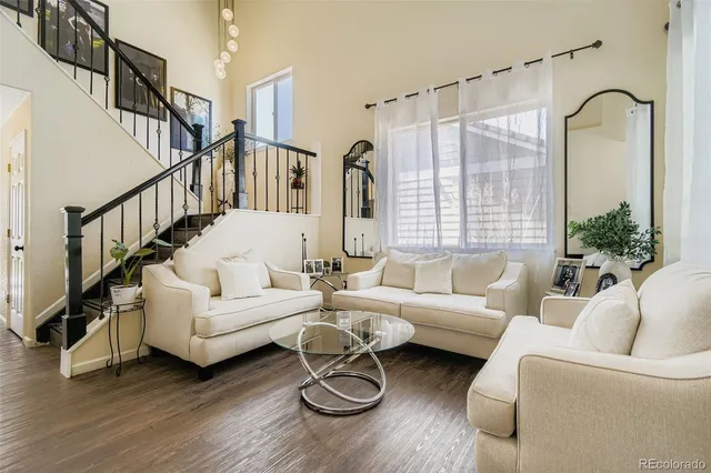 a living room with furniture potted plant and a large window