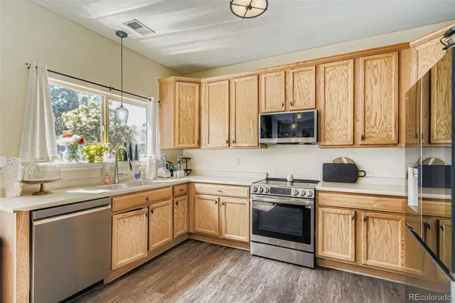 a kitchen with stainless steel appliances a stove sink microwave and cabinets