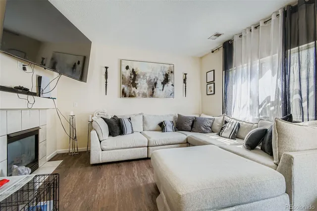 a living room with furniture a fireplace and a flat screen tv