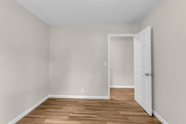 a view of an empty room with wooden floor