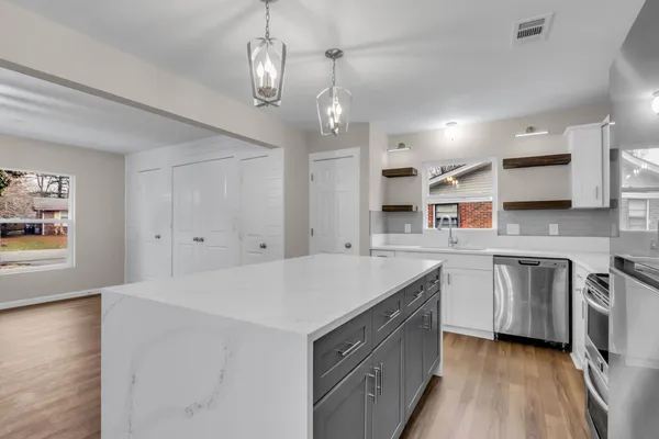 a kitchen that has a sink a stove and chairs