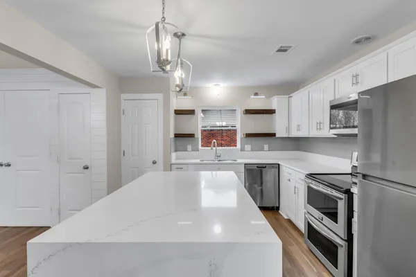 a kitchen with kitchen island a stove a sink and a refrigerator
