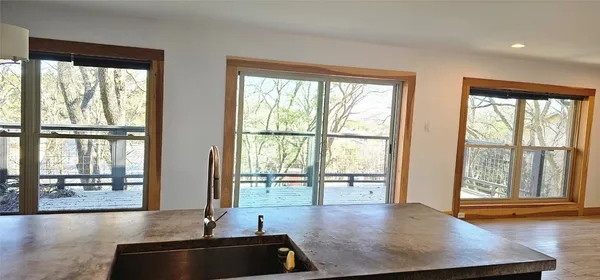 a view of a living room with hardwood floor and large windows