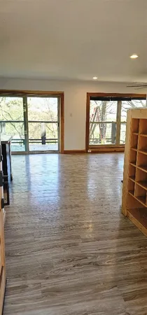 a view of empty room with wooden floor and floor to ceiling window