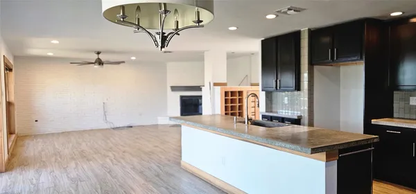 a kitchen with kitchen island granite countertop a sink appliances and cabinets