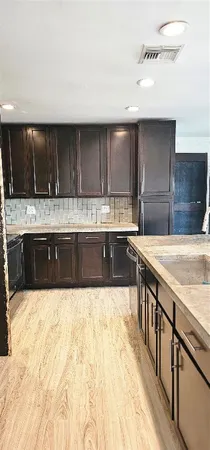 a large kitchen with stainless steel appliances a sink and a counter top space
