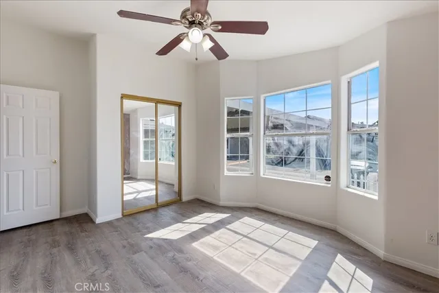 an empty room with windows and fan