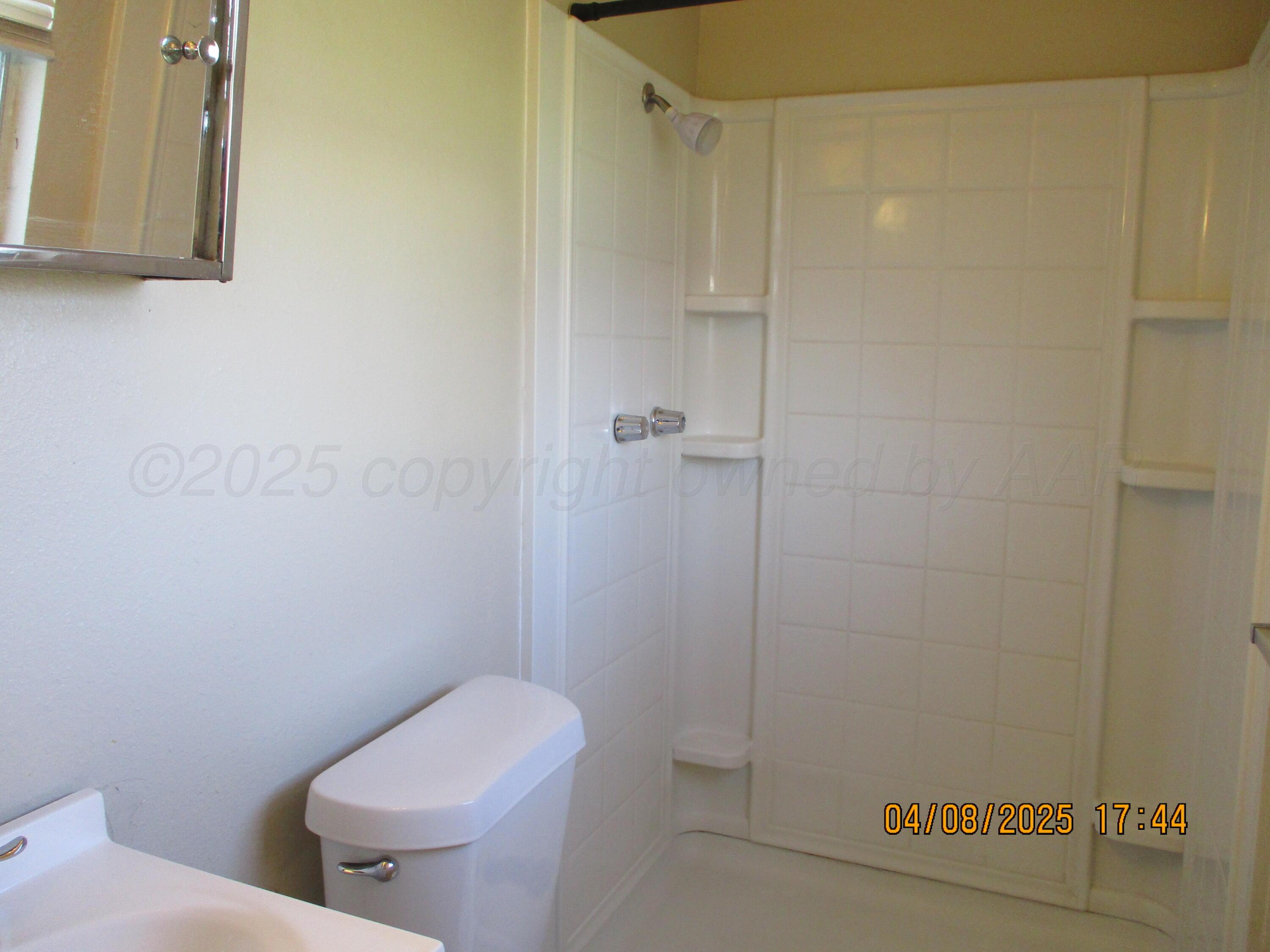 2913 Ricks Street Amarillo, TX 79103 - Photo 10 of 14 a white toilet sitting next to a shower