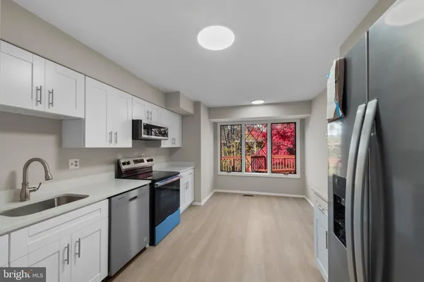 a kitchen with stainless steel appliances granite countertop a refrigerator sink and stove